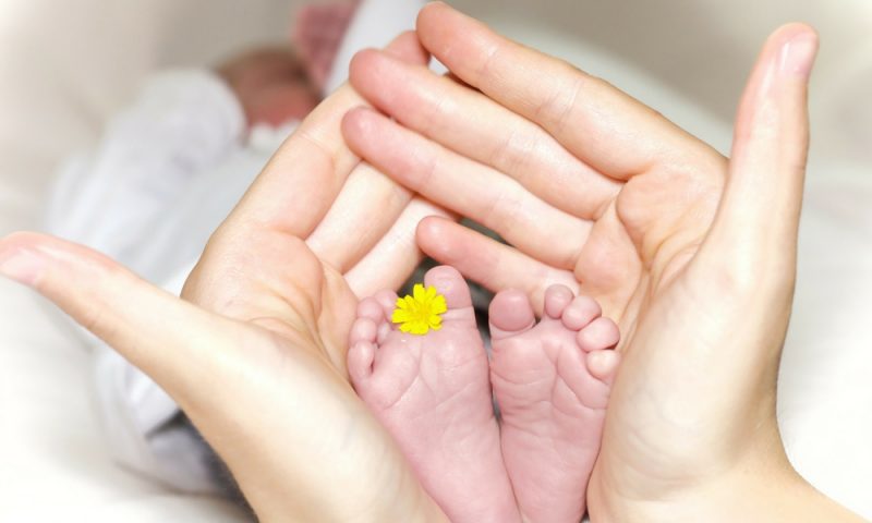 Newborn baby feet being held in Mother's hands