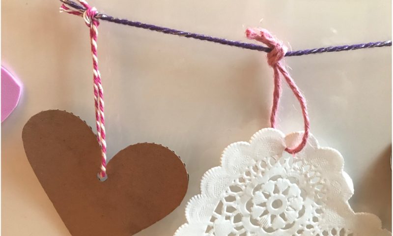 Hang each heart using string onto the longer piece of string