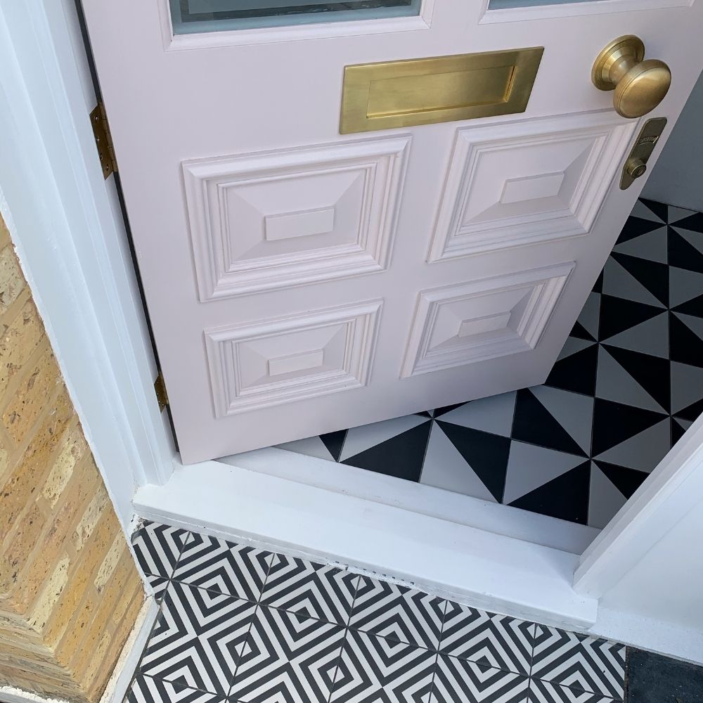 Our front door is pink surrounded by monochrome tiles