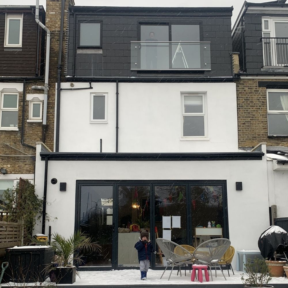 The exterior of our house is finished with white rendered walls and black or anthracite windows and doors. 