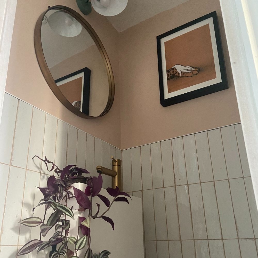 Katie transformed her understairs area into a beautiful downstairs toilet with pink walls and vertical stacked tiles. 