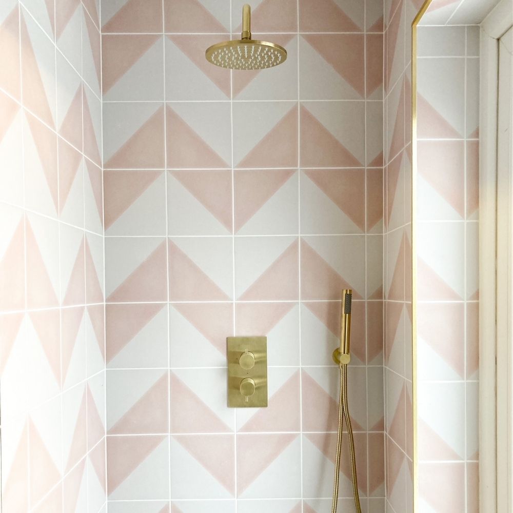 The beautiful tiled shower area featuring brass shower fittings. 
