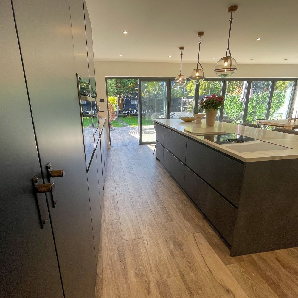 Another picture of Kelly's kitchen extension featuring a large kitchen island and bi-fold doors. 