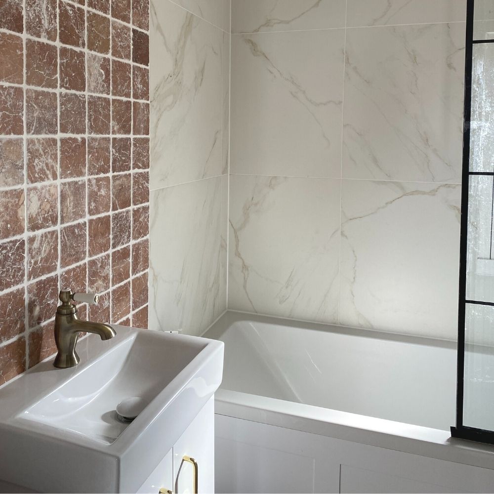 The new bathroom featuring marble and blush wall tiles. 